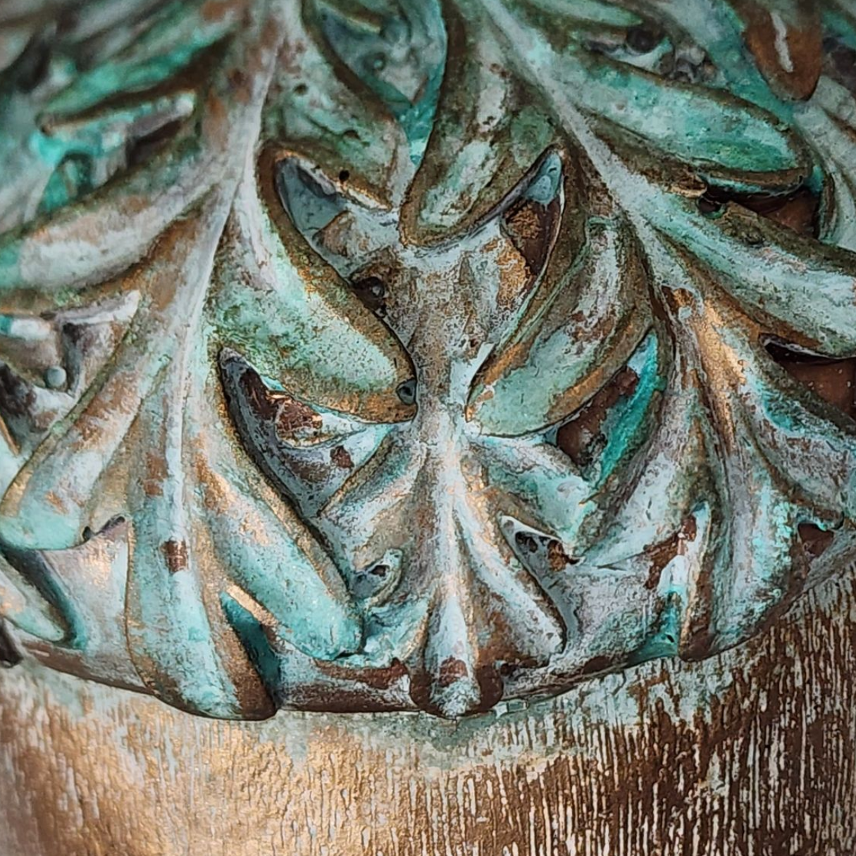 Decorative metal finial with intricate leaf pattern on a wooden background. Learn how to create this Autumn Verdigris Finish of aged bronze tones with subtle turquoise verdigris patina created using Pigment Power and Mica Powder, Glaze and more