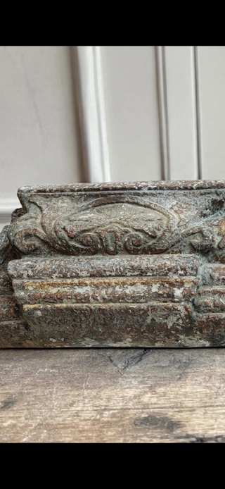Weathered Chapel Patina finish close-up showing limestone grey, oxidized green, and earthen rust tones on decorative carved surface
