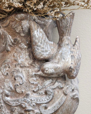 Close-up of Aged Sterling Patina Finish showing tarnished silver leaf and warm bronze tones on a carved bird wall pocket by Amy Howard At Home