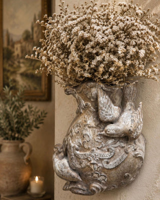 Aged Sterling Patina Finish wall pocket styled with dried botanicals showing tarnished silver and warm bronze tones in a European inspired interior by Amy Howard At Home