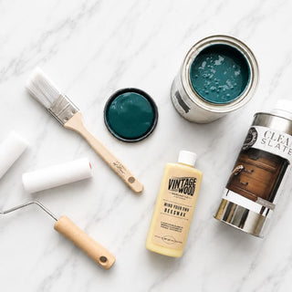 Amy Howard At Home One Step Paint beginner bundle with paint, brush, foam roller, beeswax, and Clean Slate surface prep on marble background