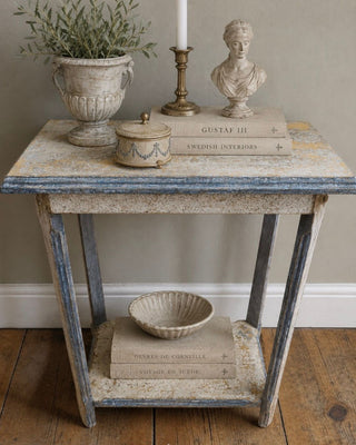 Provence Patina Finish accent table styled with olive branch, antique bust, and brass candlestick showing warm golden crackle tones and sun-washed blue trim by Amy Howard At Home