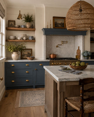 Modern kitchen with blue cabinets painted in Miracle Cabinet Paint in color Bluegrass Bliss, marble island, and wooden chair.